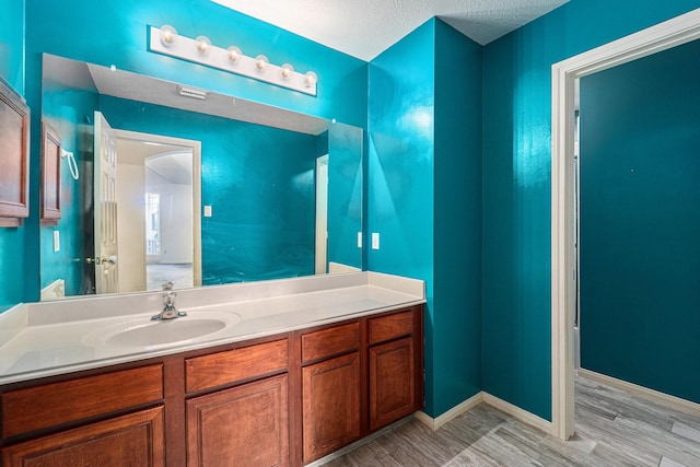 18530 S Wimbledon Dr, Katy, TX 77449 - bathroom with vanity, a textured ceiling, and wood finished floors