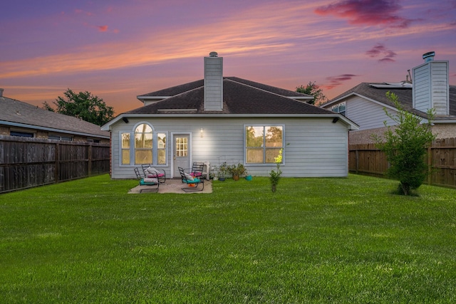 18530 S Wimbledon Dr, Katy, TX 77449 - back of property at dusk with a patio, a chimney, and roof with shingles
