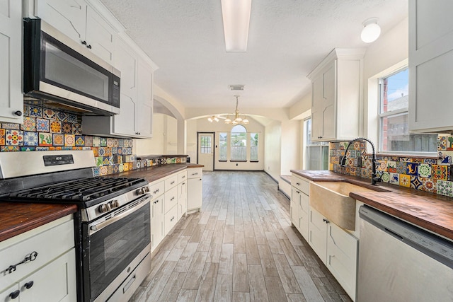 18530 S Wimbledon Dr, Katy, TX 77449 - kitchen featuring wood counters, stainless steel appliances, a sink, a chandelier, and a textured ceiling