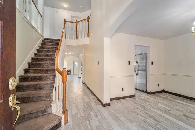 18530 S Wimbledon Dr, Katy, TX 77449 - entrance foyer with arched walkways, light wood-style flooring, and stairway