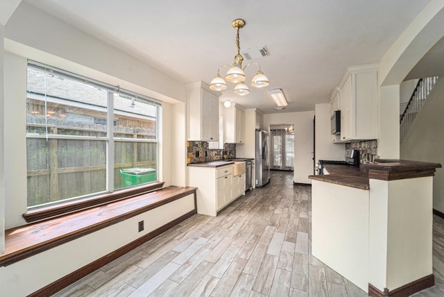 18530 S Wimbledon Dr, Katy, TX 77449 - kitchen with dark countertops, appliances with stainless steel finishes, white cabinetry, and tasteful backsplash