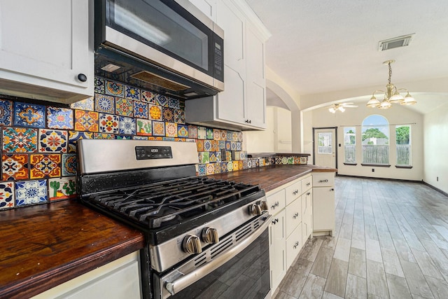 18530 S Wimbledon Dr, Katy, TX 77449 - kitchen featuring appliances with stainless steel finishes, wooden counters, a chandelier, white cabinets, and backsplash