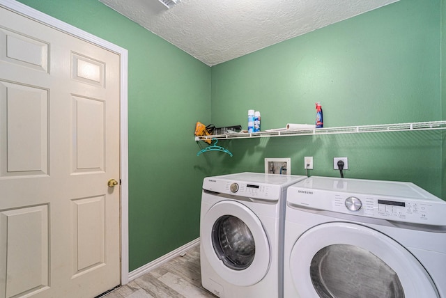 18530 S Wimbledon Dr, Katy, TX 77449 - laundry room with washing machine and dryer, a textured ceiling, light wood finished floors, and baseboards