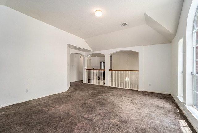 18530 S Wimbledon Dr, Katy, TX 77449 - empty room featuring carpet, lofted ceiling, and arched walkways