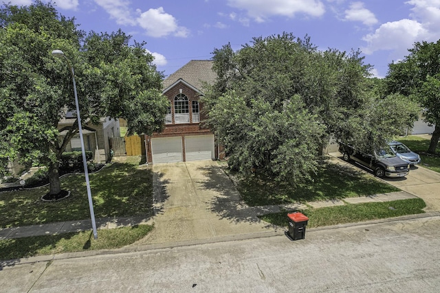 18530 S Wimbledon Dr, Katy, TX 77449 - obstructed view of property with brick siding, an attached garage, and concrete driveway