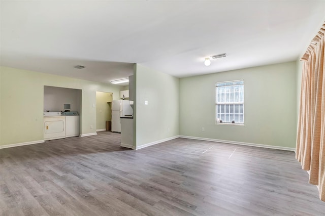 1037 Wall St, Houston, TX 77088 - unfurnished living room with washer and clothes dryer, wood finished floors, and baseboards