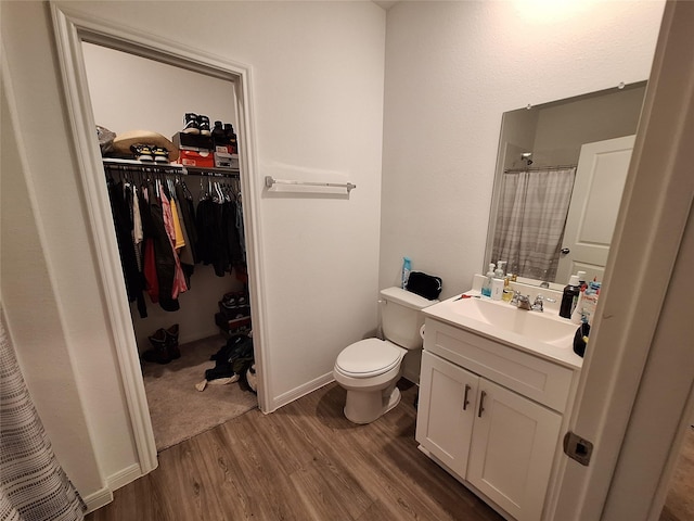 21402 Rising Fawn Rd, Porter, TX 77365 - full bathroom featuring wood finished floors, vanity, a spacious closet, toilet, and a shower with shower curtain
