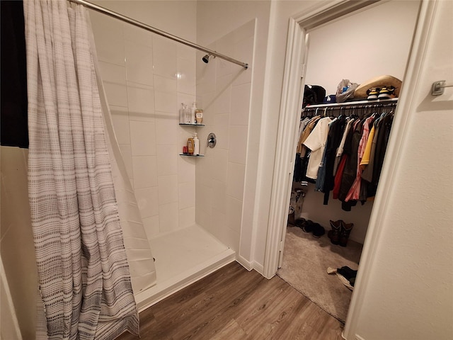 21402 Rising Fawn Rd, Porter, TX 77365 - bathroom featuring wood finished floors, tiled shower, and a walk in closet