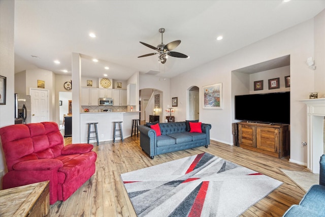 18719 Cypress Lake Village Dr, Cypress, TX 77429 - living room with arched walkways, light wood finished floors, a ceiling fan, and recessed lighting
