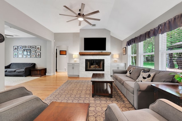 24240 Oak Hollow Blvd, Hockley, TX 77447 - living area featuring a ceiling fan, light wood-style flooring, a glass covered fireplace, vaulted ceiling, and arched walkways