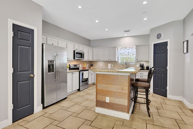 24240 Oak Hollow Blvd, Hockley, TX 77447 - kitchen with stainless steel appliances, tasteful backsplash, a sink, baseboards, and white cabinets