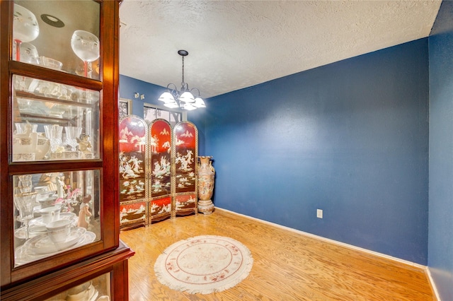 4406 Hidden Trace Ct, Houston, TX 77066 - dining space with a textured ceiling, a chandelier, baseboards, and wood finished floors