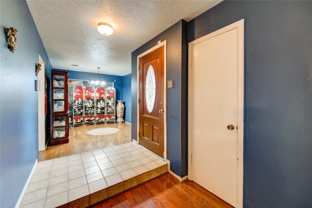 4406 Hidden Trace Ct, Houston, TX 77066 - entryway featuring a textured ceiling, wood finished floors, a chandelier, and baseboards