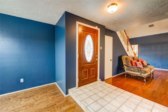 4406 Hidden Trace Ct, Houston, TX 77066 - foyer entrance with a textured ceiling, wood finished floors, stairs, and baseboards