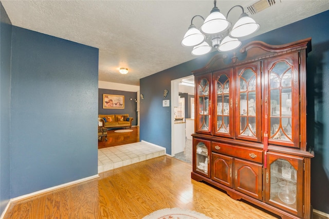 4406 Hidden Trace Ct, Houston, TX 77066 - dining space with a chandelier, light wood-type flooring, and a textured ceiling