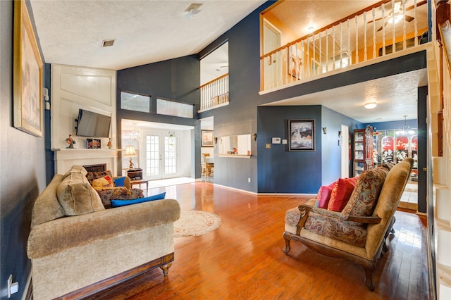 4406 Hidden Trace Ct, Houston, TX 77066 - living area featuring hardwood / wood-style flooring, a fireplace, a textured ceiling, high vaulted ceiling, and baseboards