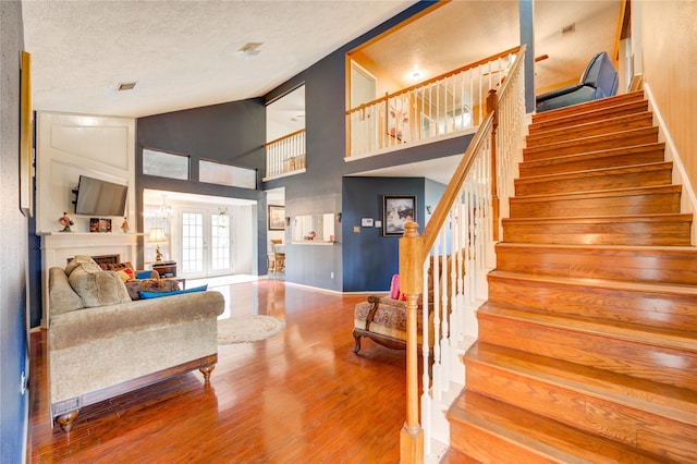 4406 Hidden Trace Ct, Houston, TX 77066 - living area with stairway, wood finished floors, a fireplace, a textured ceiling, and baseboards