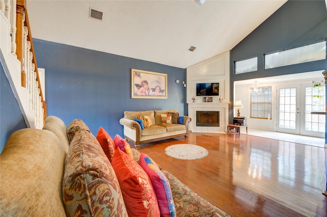 4406 Hidden Trace Ct, Houston, TX 77066 - living room featuring wood finished floors, high vaulted ceiling, stairs, a large fireplace, and french doors