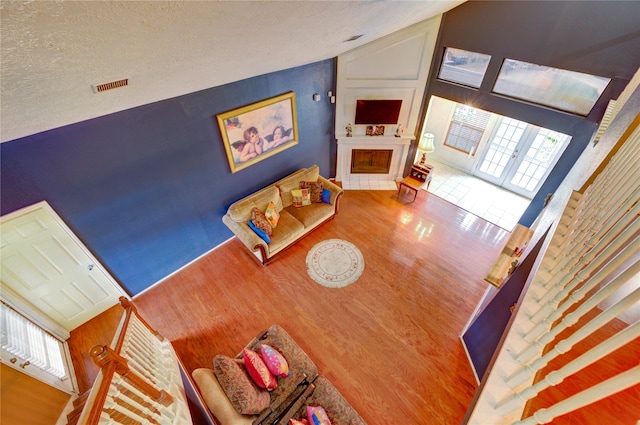4406 Hidden Trace Ct, Houston, TX 77066 - living room featuring wood finished floors, a fireplace, vaulted ceiling, and a textured ceiling