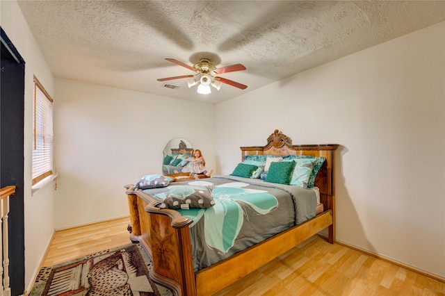 4406 Hidden Trace Ct, Houston, TX 77066 - bedroom with light wood-style flooring, ceiling fan, and a textured ceiling