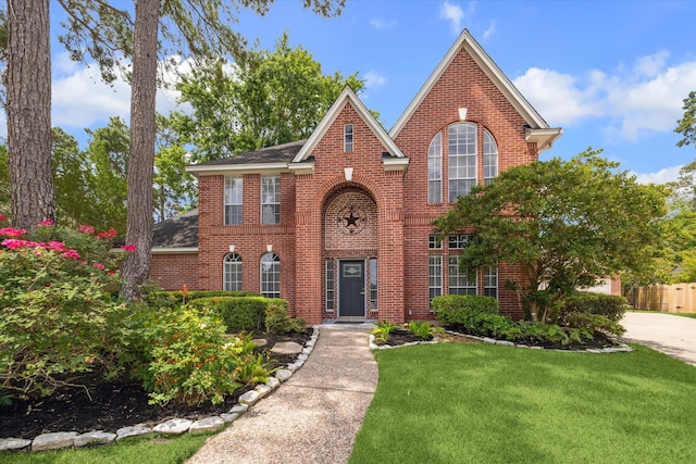 18715 Big Cypress Dr, Spring, TX 77388 - colonial-style house with brick siding, a front yard, and a shingled roof