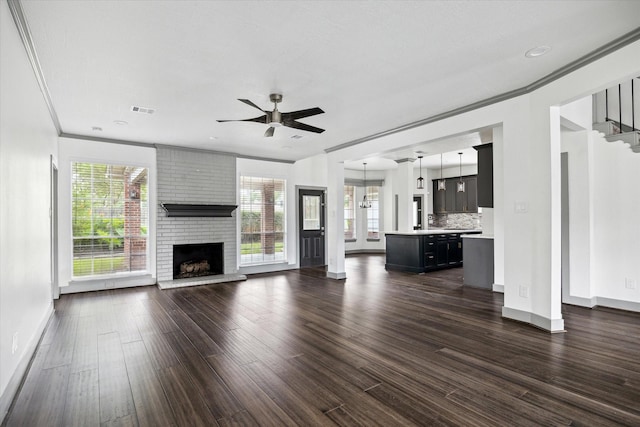 18715 Big Cypress Dr, Spring, TX 77388 - unfurnished living room featuring baseboards, dark wood-type flooring, ceiling fan, a fireplace, and crown molding