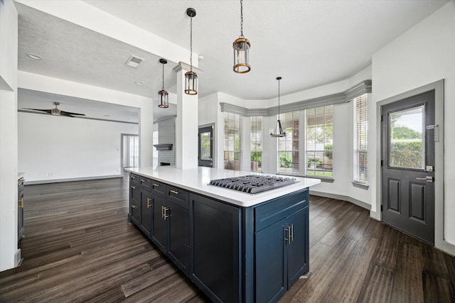 18715 Big Cypress Dr, Spring, TX 77388 - kitchen with stainless steel gas cooktop, dark wood finished floors, blue cabinetry, light countertops, and a textured ceiling