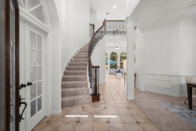 35 Dewdrift Pl, The Woodlands, TX 77382 - carpeted entrance foyer with tile patterned floors, stairs, baseboards, ceiling fan, and decorative columns