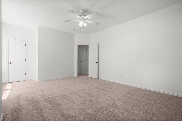 35 Dewdrift Pl, The Woodlands, TX 77382 - unfurnished bedroom featuring light colored carpet, baseboards, and a ceiling fan