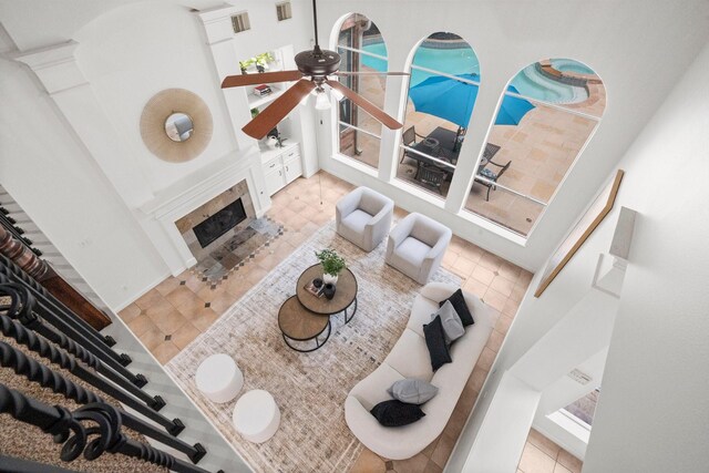 35 Dewdrift Pl, The Woodlands, TX 77382 - tiled living area featuring a ceiling fan, a towering ceiling, and a fireplace