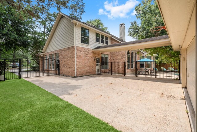 35 Dewdrift Pl, The Woodlands, TX 77382 - back of house featuring a gate, brick siding, a chimney, and a patio area