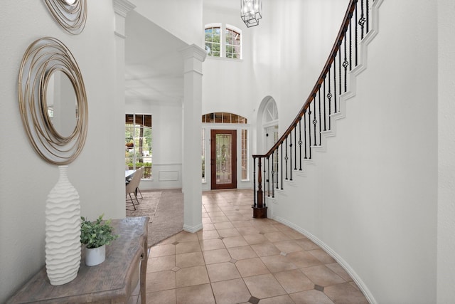 35 Dewdrift Pl, The Woodlands, TX 77382 - foyer with plenty of natural light, ornate columns, a chandelier, light tile patterned flooring, and a high ceiling