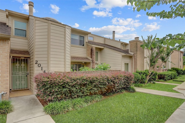 2014 Augusta Dr, Houston, TX 77057 - view of front facade featuring a front yard, brick siding, and a chimney