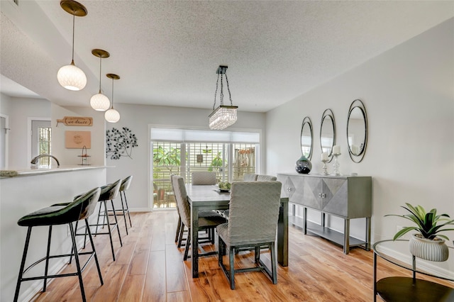 2014 Augusta Dr, Houston, TX 77057 - dining area with a textured ceiling, plenty of natural light, light wood-style floors, and baseboards