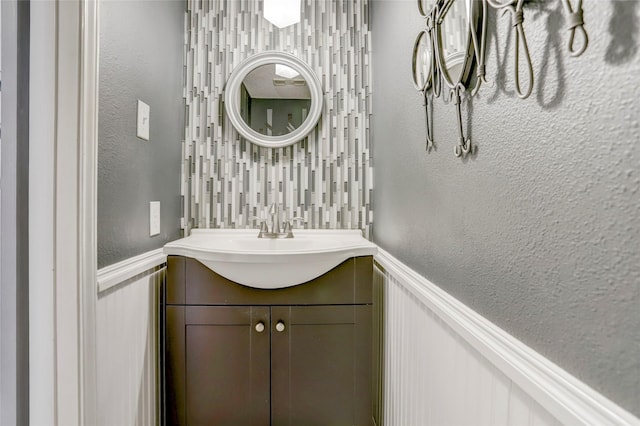 2014 Augusta Dr, Houston, TX 77057 - bathroom featuring wainscoting, vanity, a decorative wall, and a textured wall