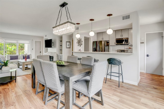 2014 Augusta Dr, Houston, TX 77057 - dining space featuring light wood finished floors and a fireplace