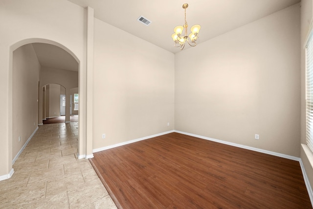 25426 Saddlebrook Champion Way, Tomball, TX 77375 - spare room with lofted ceiling, baseboards, arched walkways, and a chandelier
