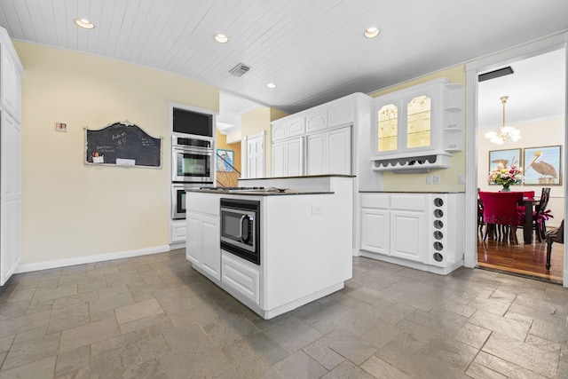 718 Pine Rd, Clear Lake Shores, TX 77565 - kitchen with stone tile flooring, a chandelier, recessed lighting, appliances with stainless steel finishes, and white cabinets