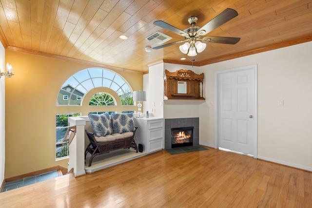 718 Pine Rd, Clear Lake Shores, TX 77565 - living room featuring ornamental molding, wood finished floors, ceiling fan, a tiled fireplace, and wood ceiling