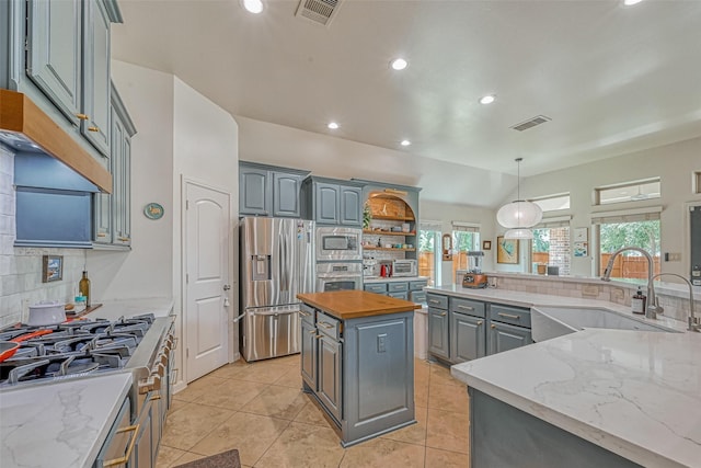 5918 Emmit Creek Ln, Sugar Land, TX 77479 - kitchen featuring appliances with stainless steel finishes, a sink, gray cabinets, a large island, and decorative backsplash