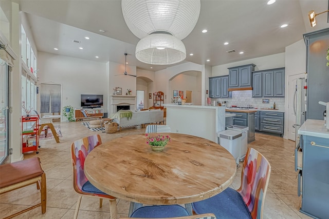 5918 Emmit Creek Ln, Sugar Land, TX 77479 - dining area featuring light tile patterned floors, a fireplace, arched walkways, and recessed lighting