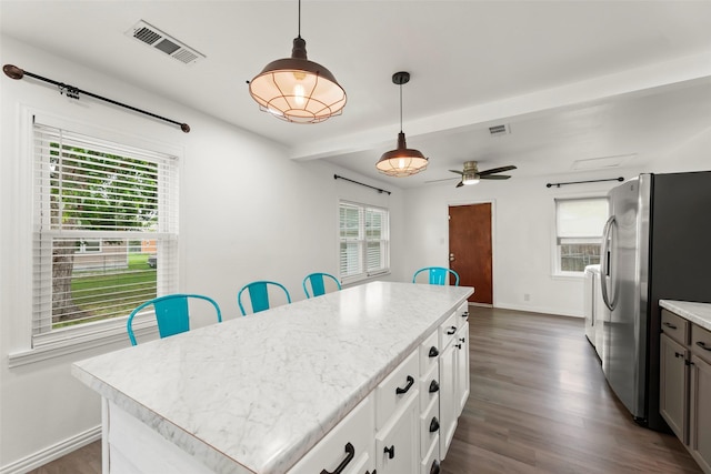 7009 Tuck St, Houston, TX 77020 - kitchen with freestanding refrigerator, light countertops, a center island, dark wood-style floors, and beamed ceiling