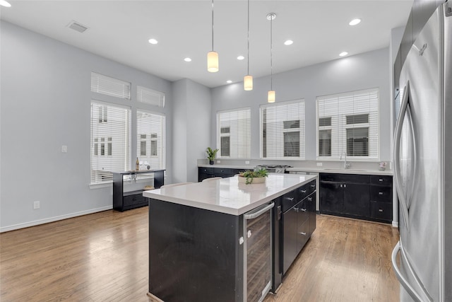 2719 Clay St, Houston, TX 77003 - kitchen with freestanding refrigerator, beverage cooler, light wood finished floors, a center island, and recessed lighting