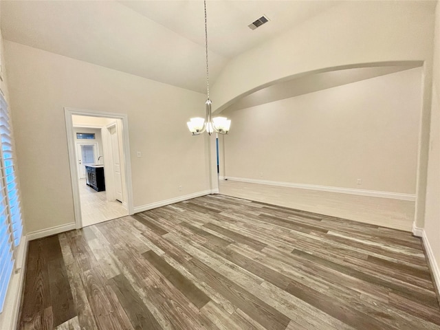 2023 Deer Vly, Missouri City, TX 77459 - unfurnished dining area with a chandelier, wood finished floors, baseboards, arched walkways, and lofted ceiling