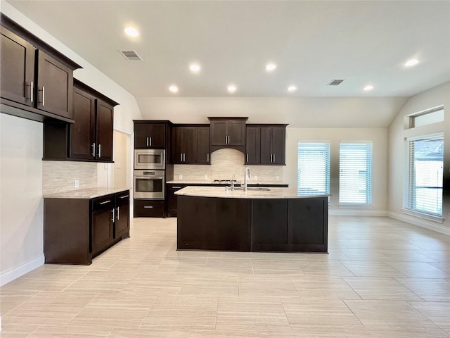 2023 Deer Vly, Missouri City, TX 77459 - kitchen featuring appliances with stainless steel finishes, recessed lighting, decorative backsplash, a center island with sink, and lofted ceiling