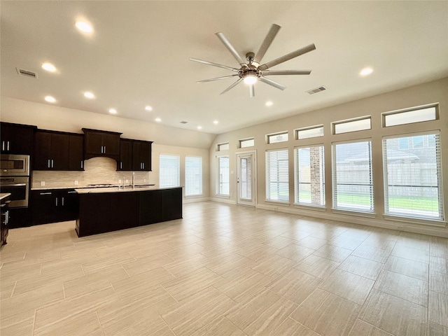 2023 Deer Vly, Missouri City, TX 77459 - kitchen featuring stainless steel microwave, open floor plan, a ceiling fan, a sink, and backsplash