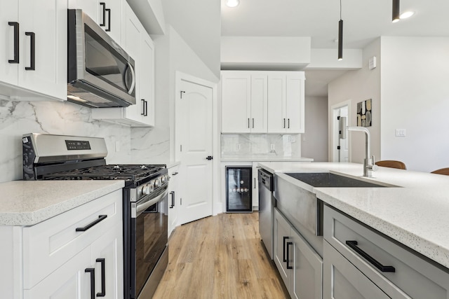 3722 Nathaniel Brown St, Houston, TX 77021 - kitchen with stainless steel appliances, decorative backsplash, a sink, light stone counters, and wine cooler