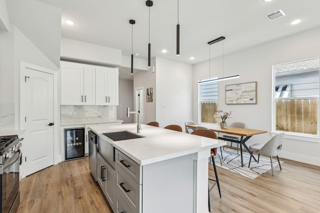 3722 Nathaniel Brown St, Houston, TX 77021 - kitchen with beverage cooler, gas range oven, a sink, a kitchen breakfast bar, and light wood-style floors