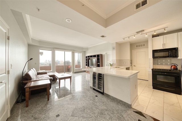 3505 Sage Rd Unit 2405, Houston, TX 77056 - kitchen with black appliances, beverage cooler, a peninsula, open floor plan, and light countertops