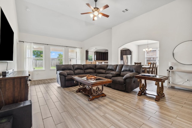 20423 Barrel Run Dr, Hockley, TX 77447 - living room with arched walkways, light wood-style flooring, a ceiling fan, high vaulted ceiling, and a chandelier